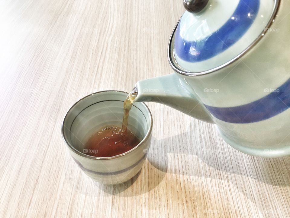 Tea being poured into cup from teapot