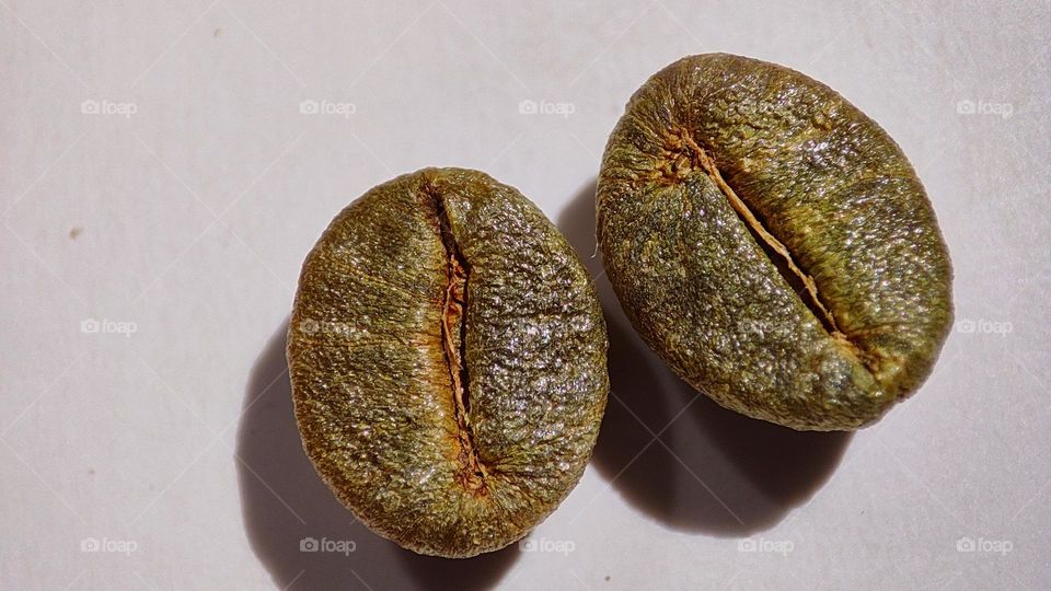 macro image of golden colour Coffee beans on a white surface