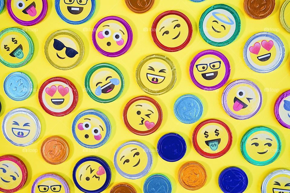 Bangkok, Thailand - Jan 13, 2019 : A photo of chocolate Emoji coins. Top view photo of chocolate coins with various expressions, pop art style, on a yellow background.