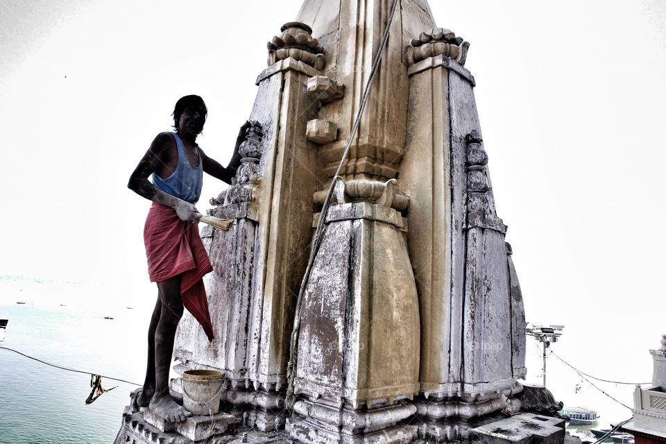 Hard at work with River Ganges in background . Man continues to ask me to take photo 