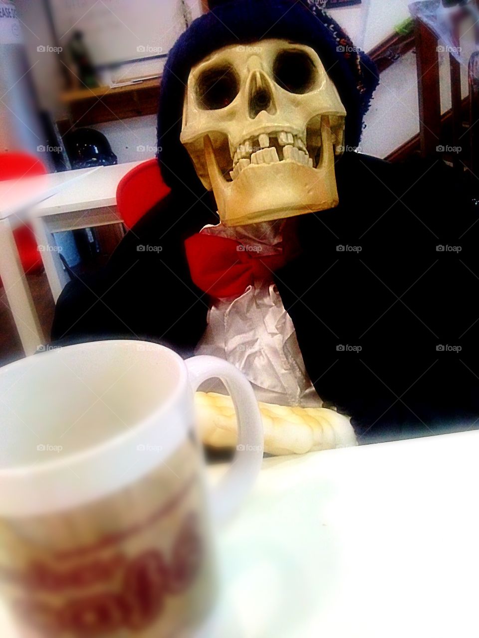 Tea with a skeleton . Halloween display in a cafe. A skeleton sat at the table with a brew.
