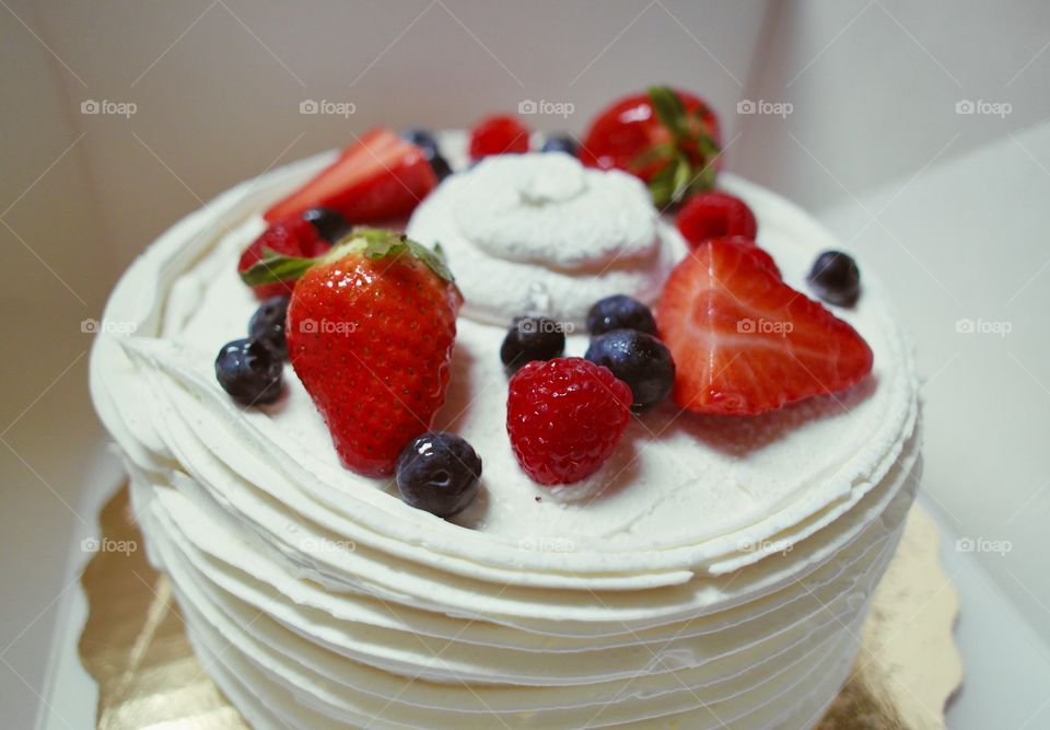 Strawberry and blueberry cake with white frosting 