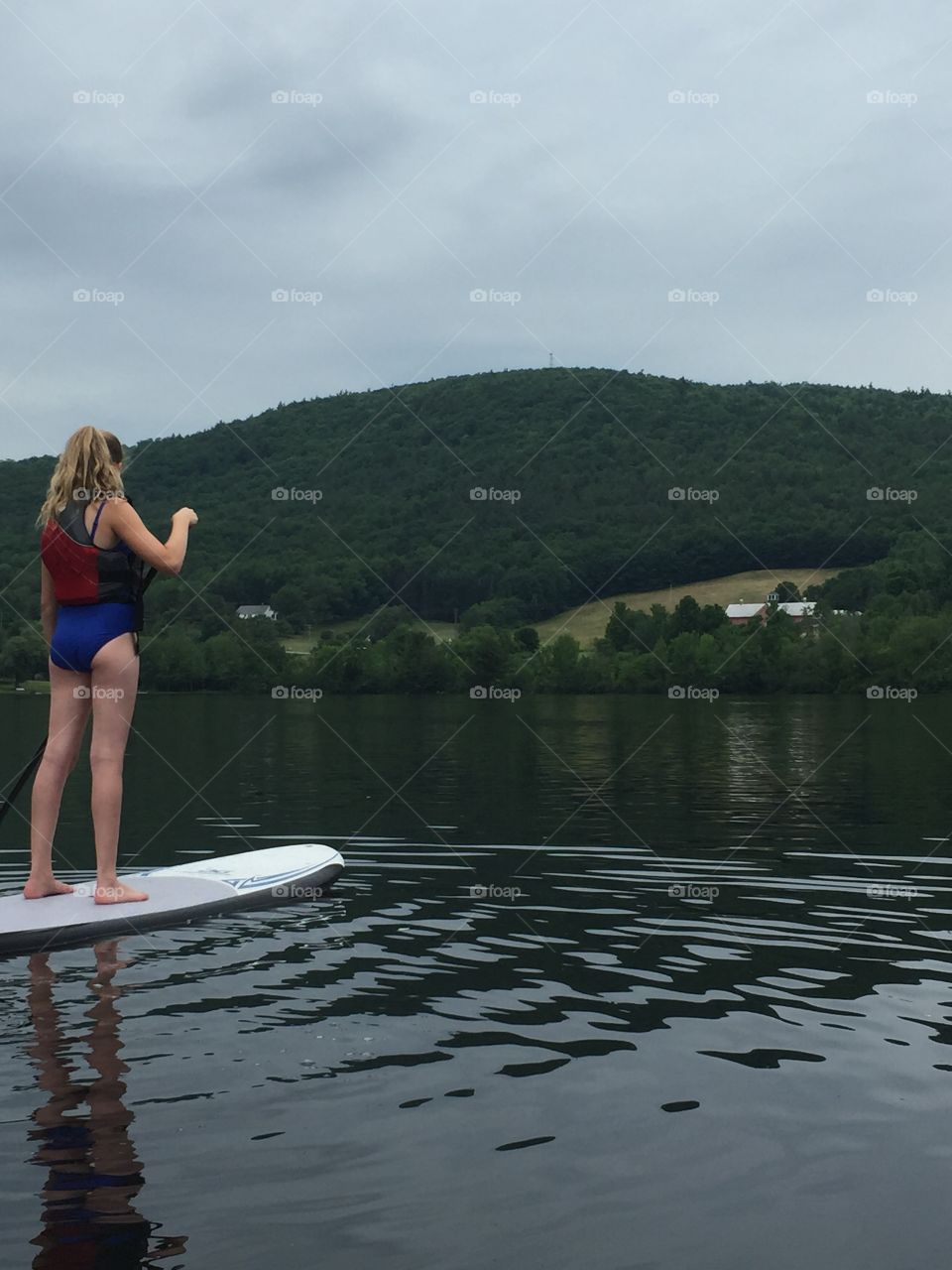 Mountain side view from lake with girl looking out