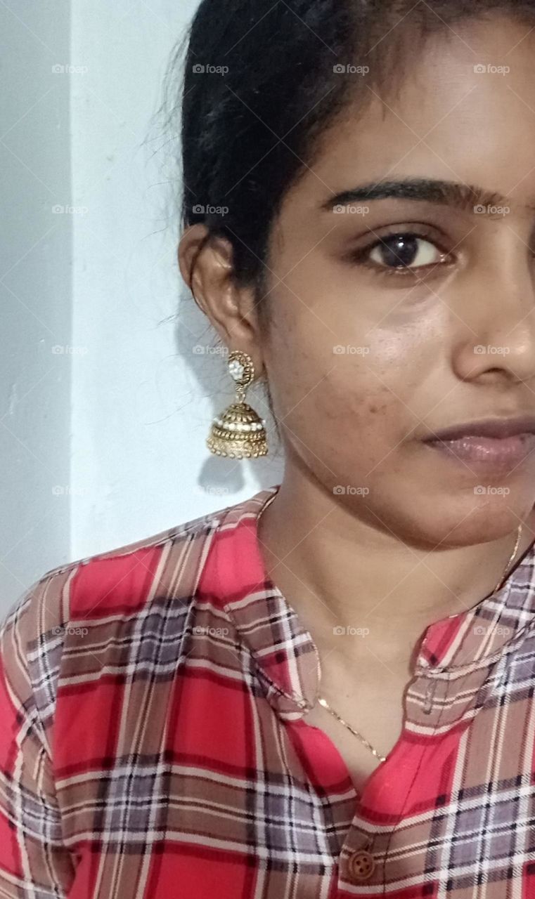 one side face close up photo without makeup but with earring