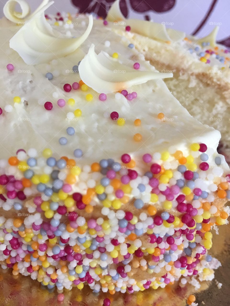 Close up view of delicious gluten free vanilla celebration cake with sprinkles 