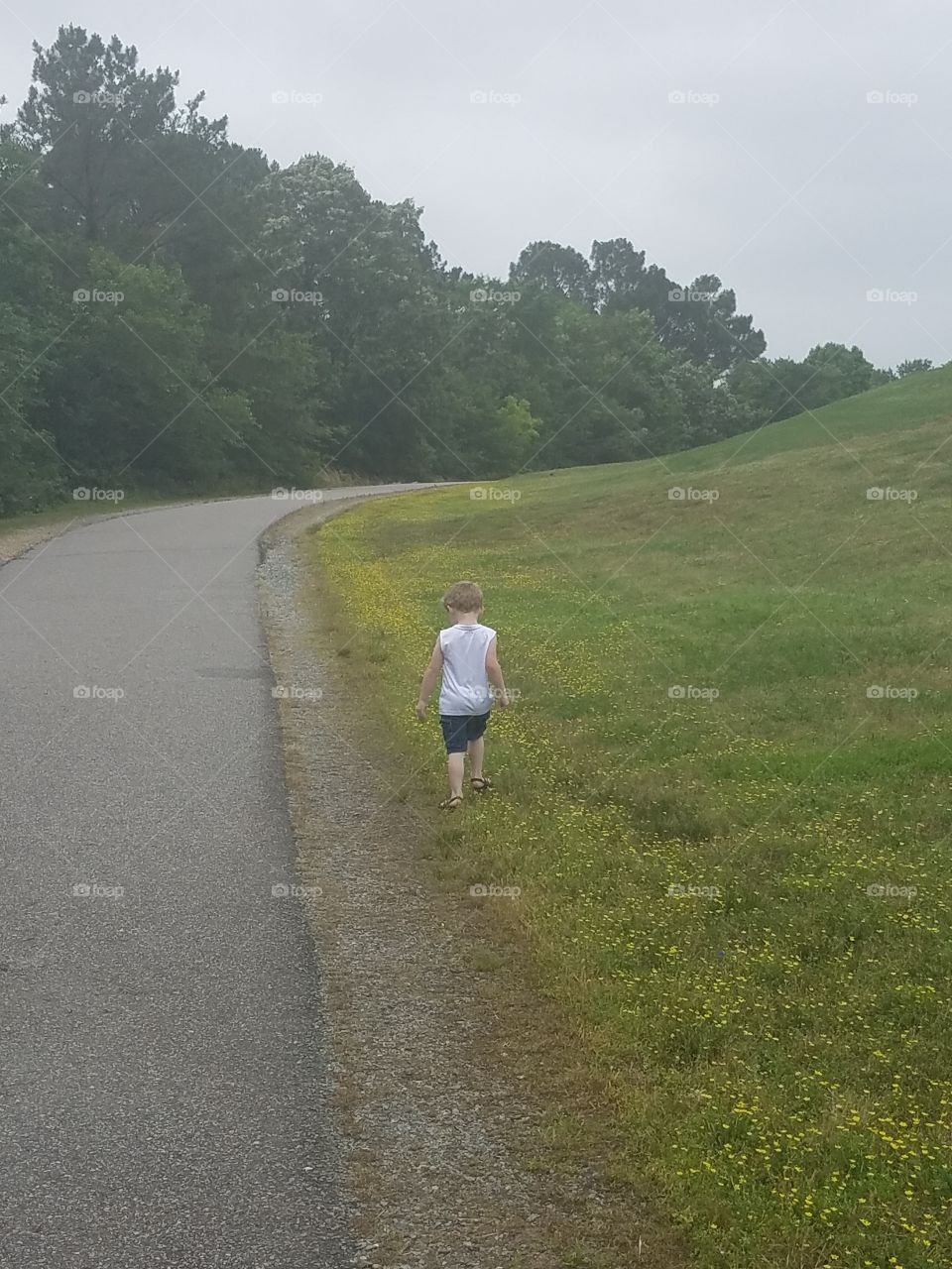 boy walking alongside a road