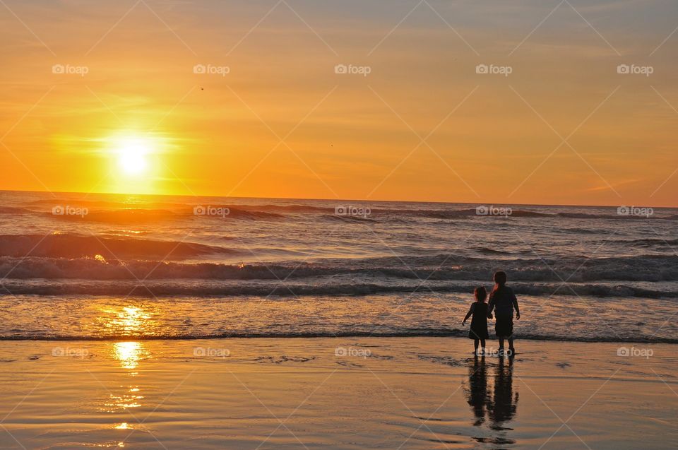 Ocean Sunset. Silhouette of 2 children on beach at sunset 