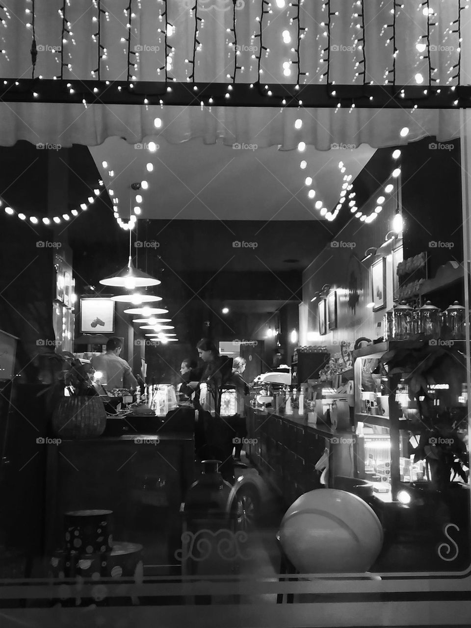 Festive atmosphere in the cafe. A look through the window. Black and white photo