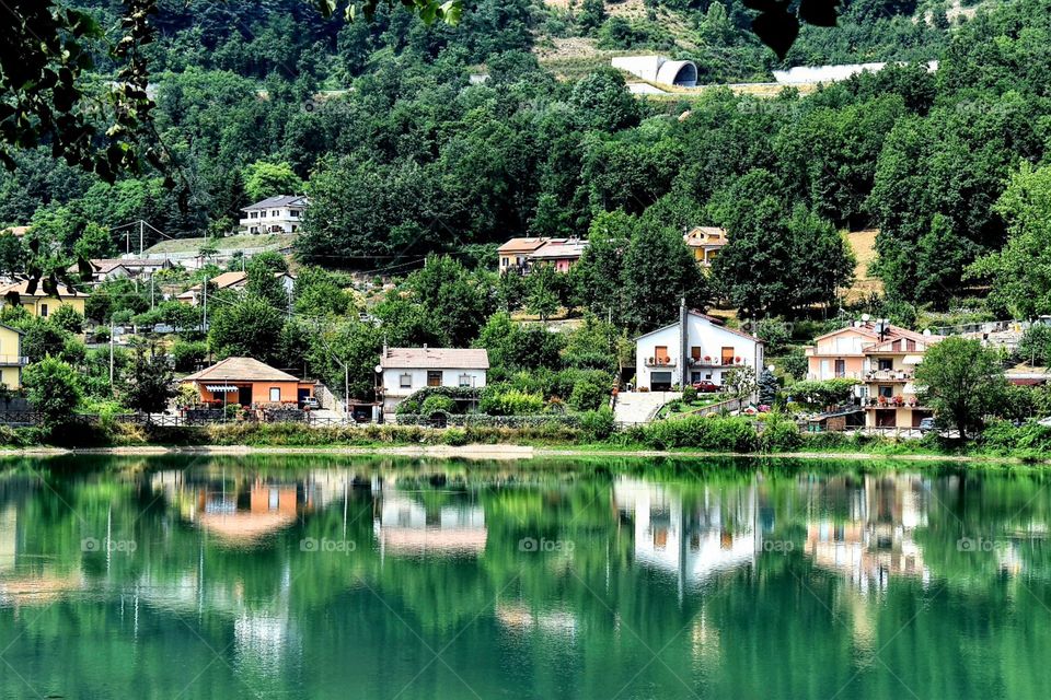reflection of houses and trees near lake