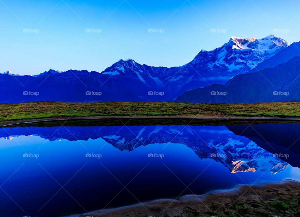 reflection of mountain on the lake water forming an epic view