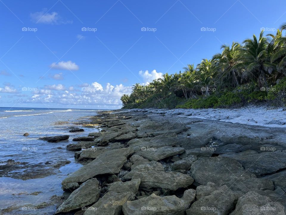 Blue sky covering the horizon of the island line of the Famous Gnaviyani Fuvahmulah in the Maldives. Nature finds it's own way to uncover the reef and it's stones seasonally.