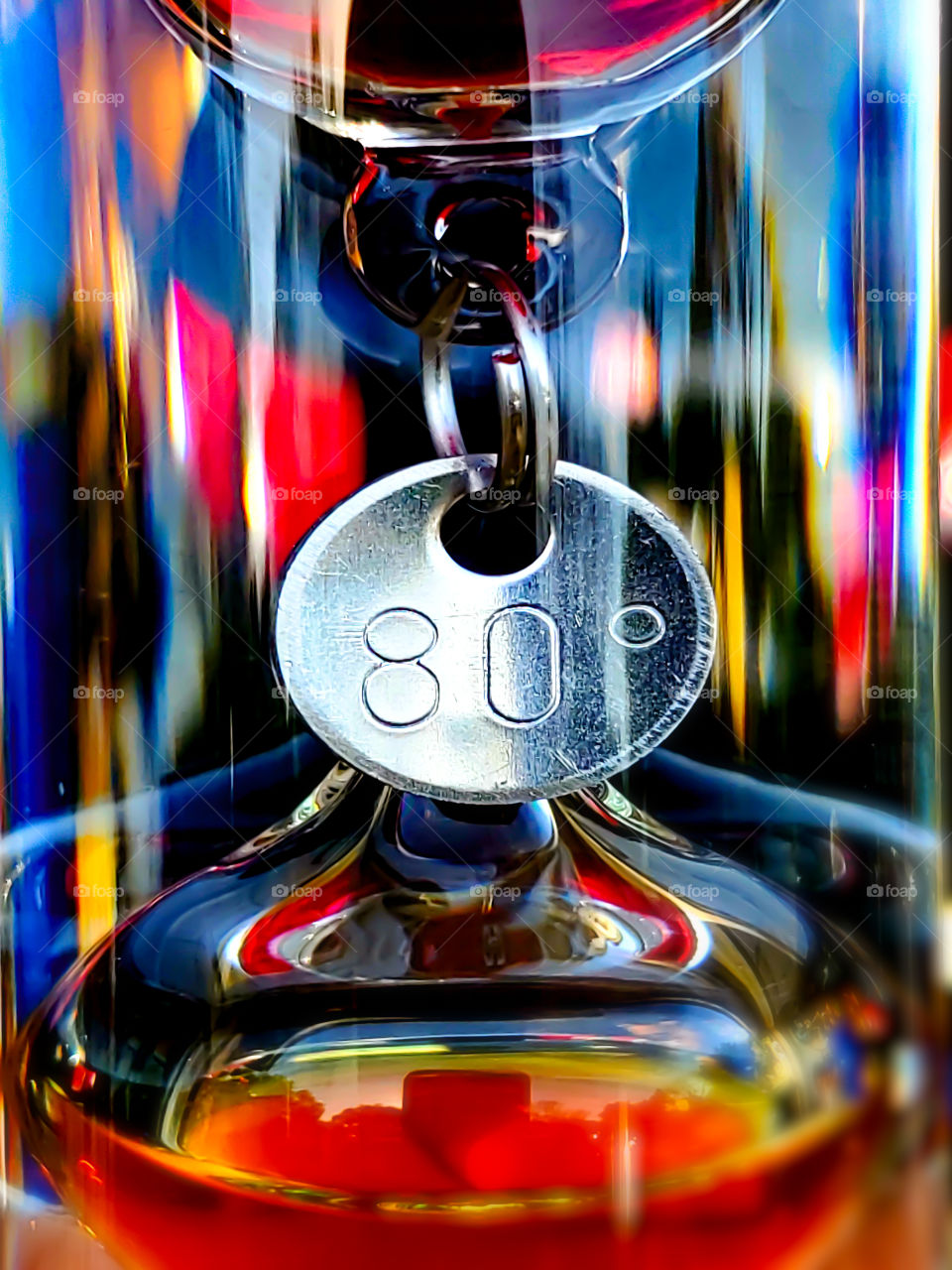 Abstract of a Galileo thermometer macro with colorful reflections on the thermometers cylinder glass