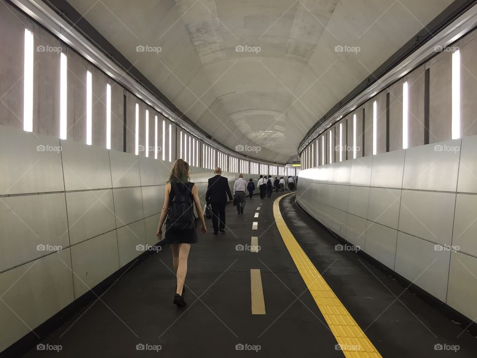 People walking through a tunnel in Tokyo.