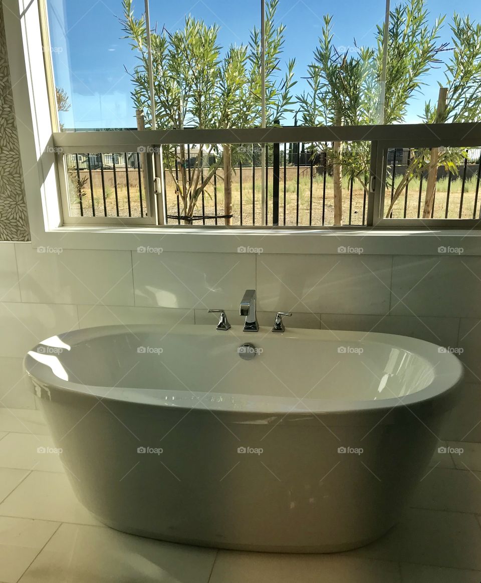 The bathroom with beautiful natural sunlight shining through the big glass window - home 