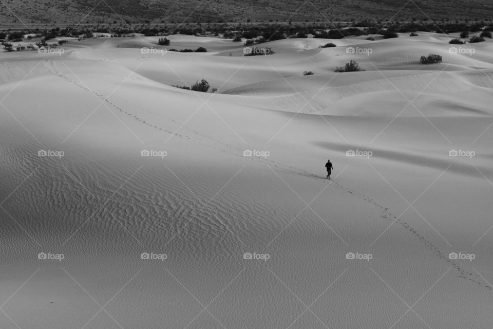 Man walking on sand dune