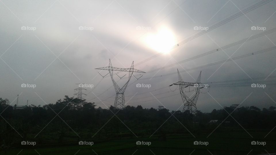 evening sun above a high voltage power grid
