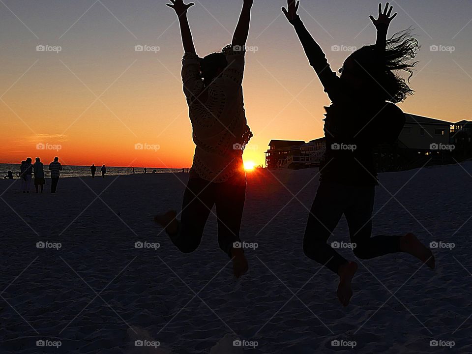 Jumping for joy in the sunset- sisters elated by the magnificent sunset muster enough energy to jump in the air