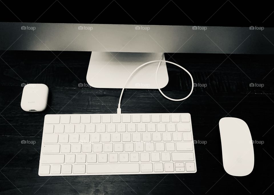 Apple Computer, mouse and headphones on display on the wooden office desk 