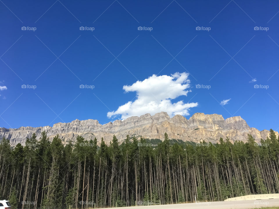 castle mountain Alberta highway 1 with a clear blue sky and one fluffy cloud