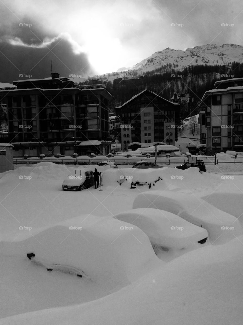 An Italian village in the alps covered in snow and cars / Black and White