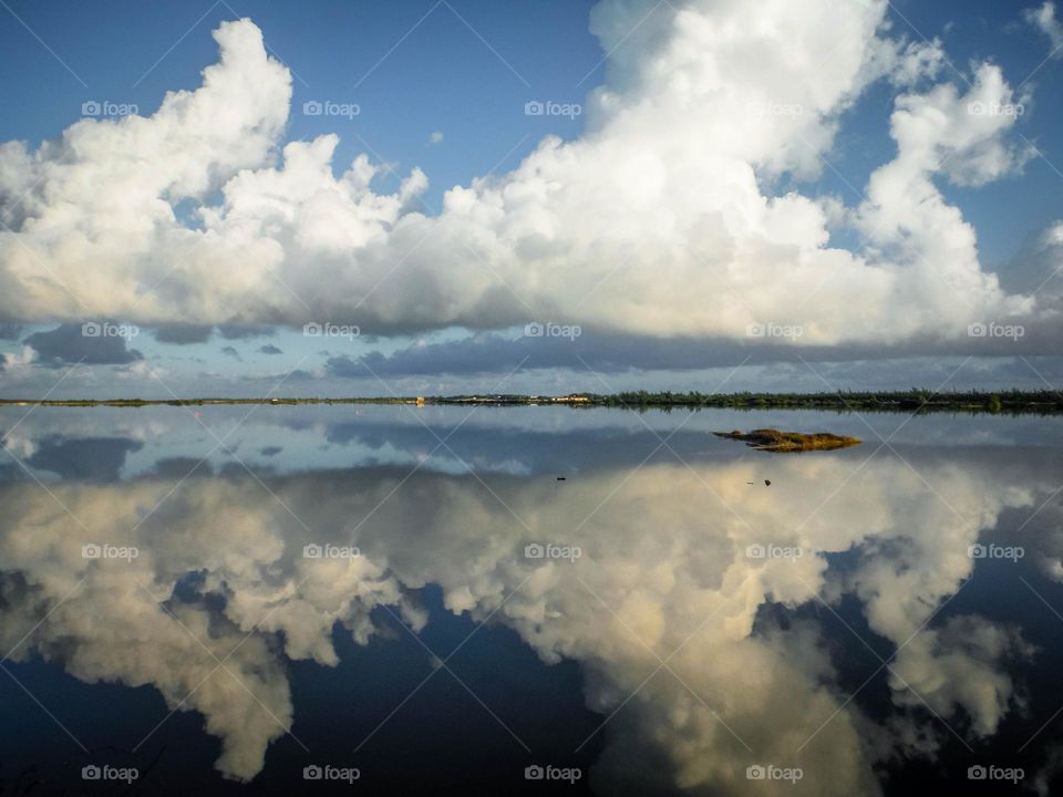 White beautiful clouds on tge sky and in a reflection