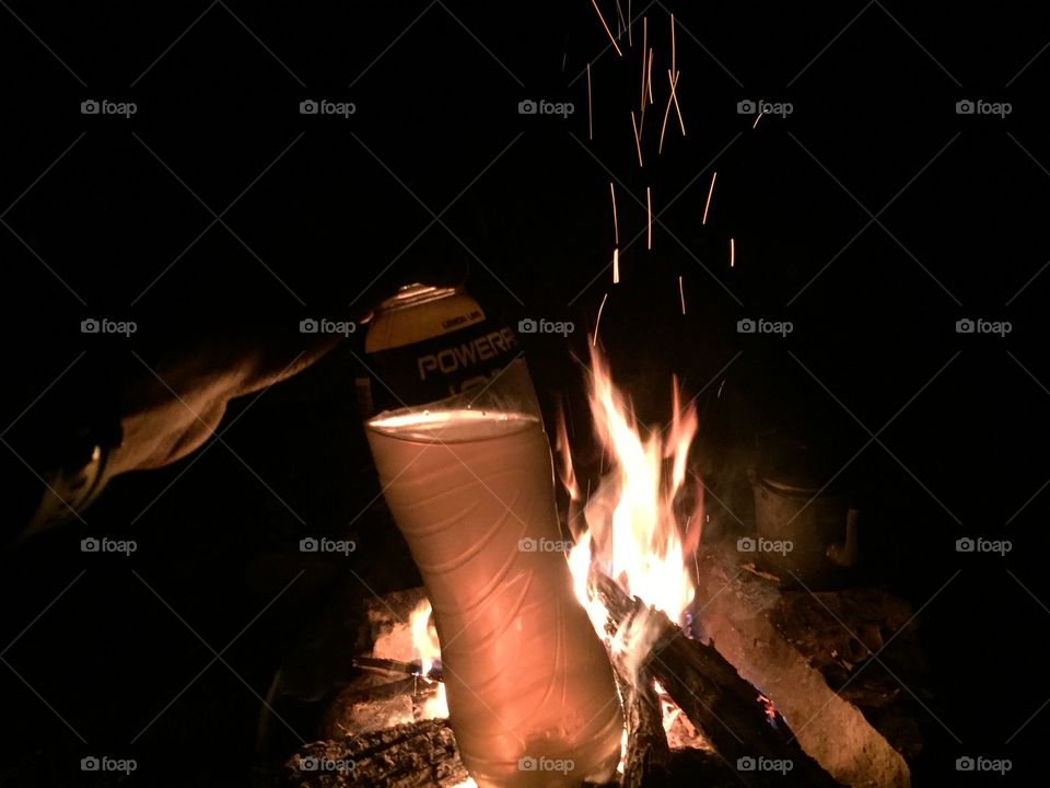 Water bottle with fire glowing behind it