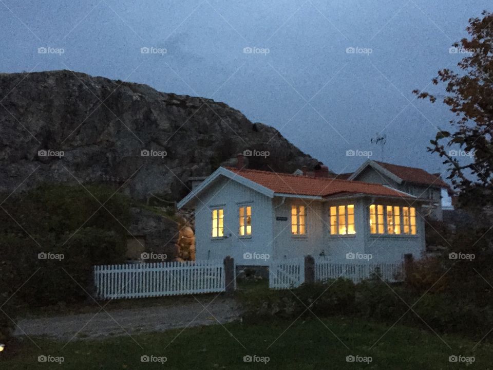 The house and the rock. A small house by the foot of the big rock