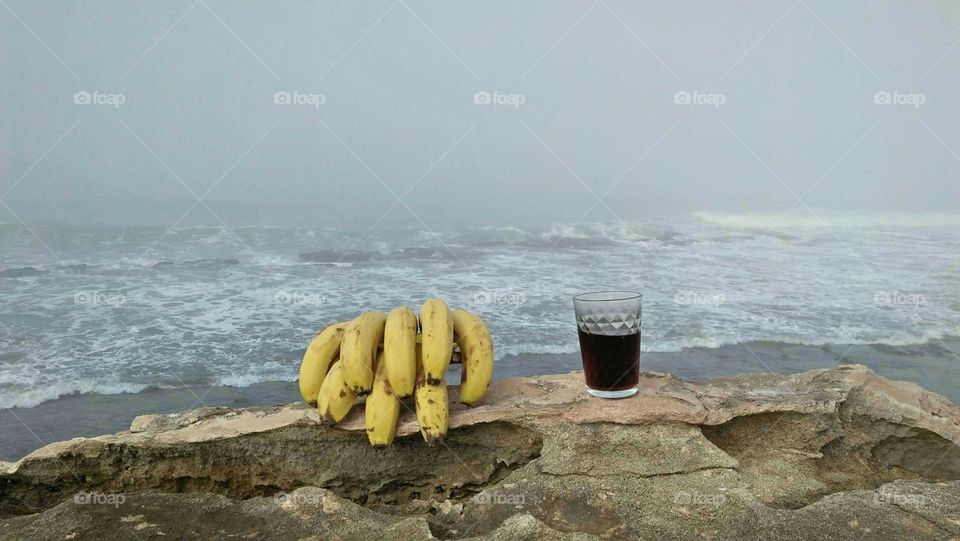 Beautiful view of sea and delicious bananas near a cup of cocacola.