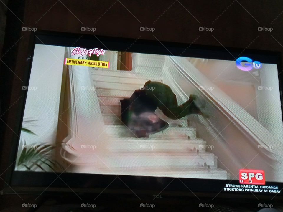 A SCENE FROM THE MOVIE, " MERCENARY ABSOLUTION",, WHERE THE BAD GUY FALLS ON YHE CONCRETE STAIRS,