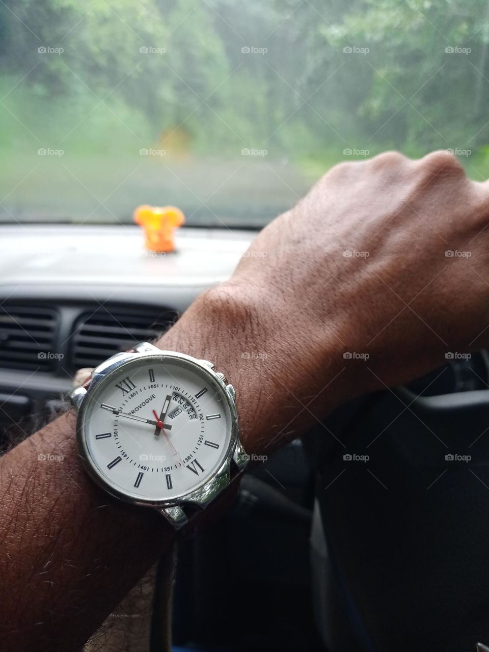 young man wearing beautiful watch with nice white colour dail it's looking amazing when drive the car
