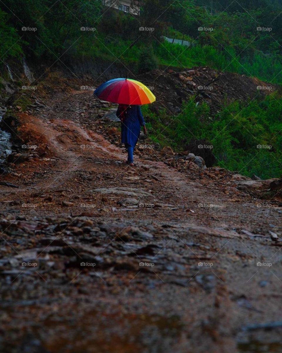 Coming down from the hill with a rainbow umbrella