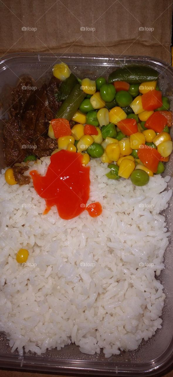 Plastic box rice filled with beef rendang, vegetables and beans