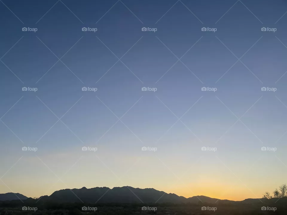 A yellow sunset with mountains.
