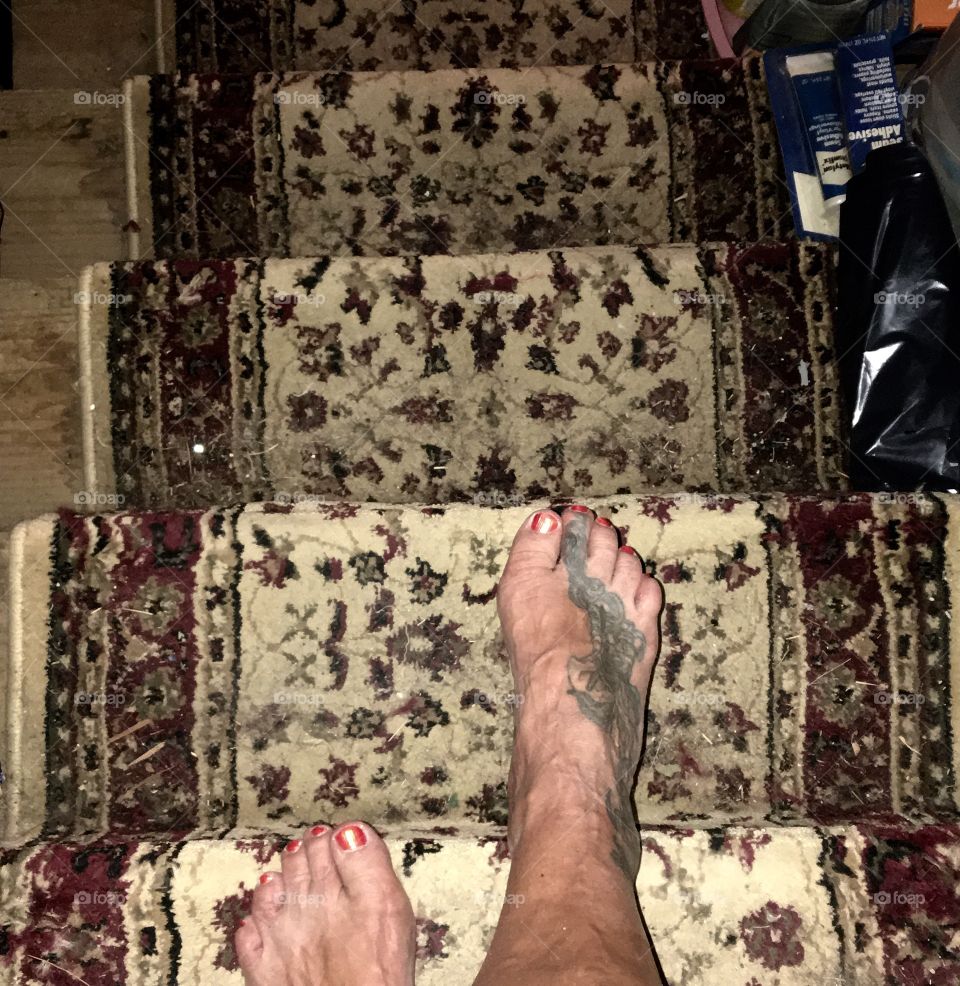 Lady walking down stairs barefoot.