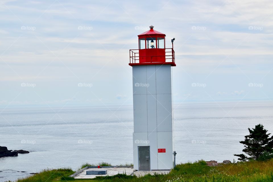 A Canada lighthouse on a summer day in New Brunswick Canada by the ocean on a road trip 