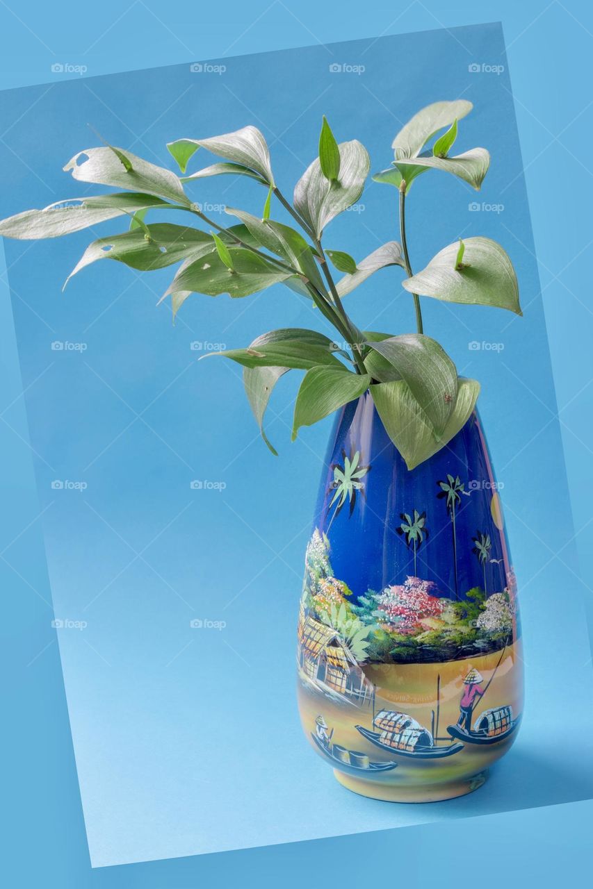 Vase with flower on blue background