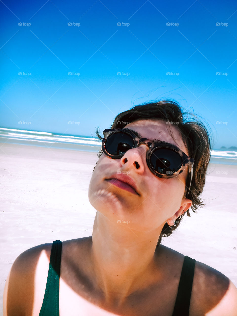 Beautiful Girl at the beach, nice portrait, with shadows on her face. Pretty powerful portrait.