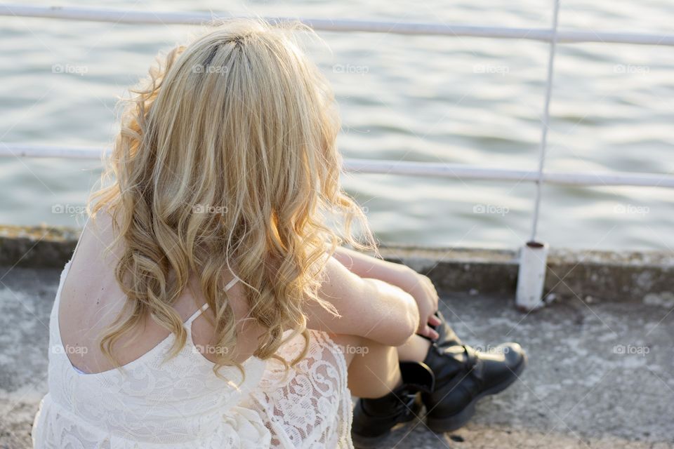 woman enjoying sunset. woman wearing white laced dress enjoying sunset