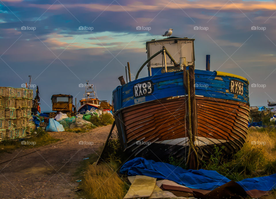 Fishing boat RX83 sits on the working, fisherman’s beach on a dusky evening in Hastings, UK 