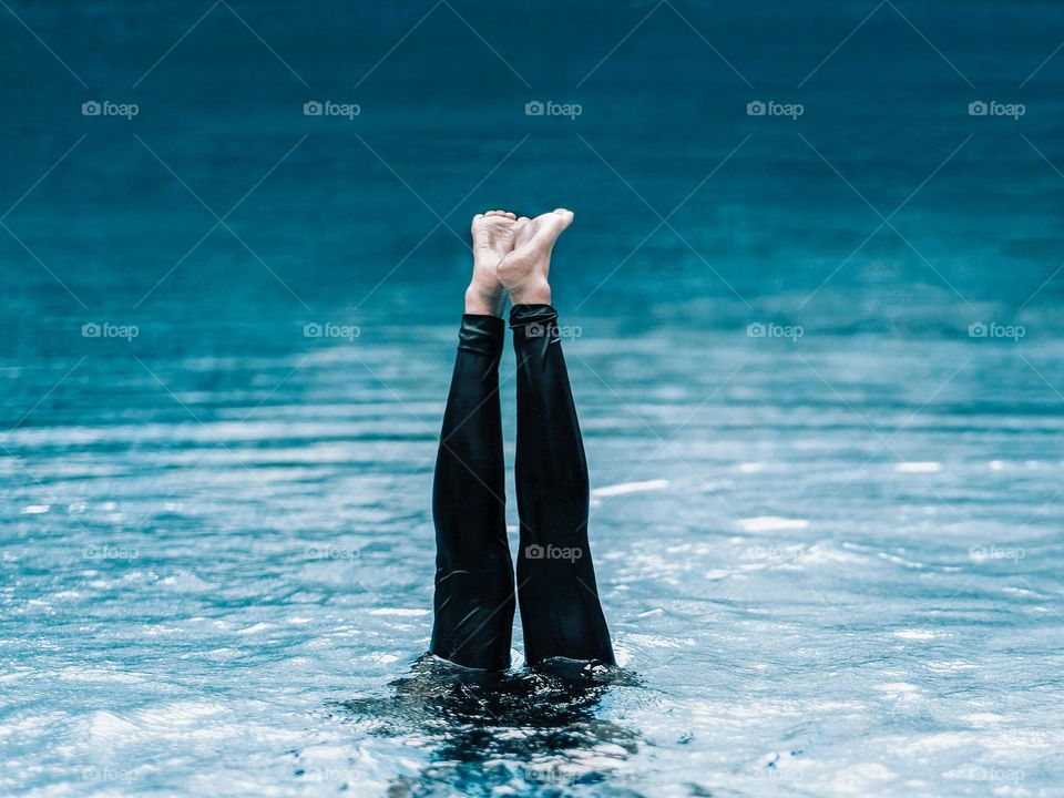 A young girl doing a water ballet move in a pool