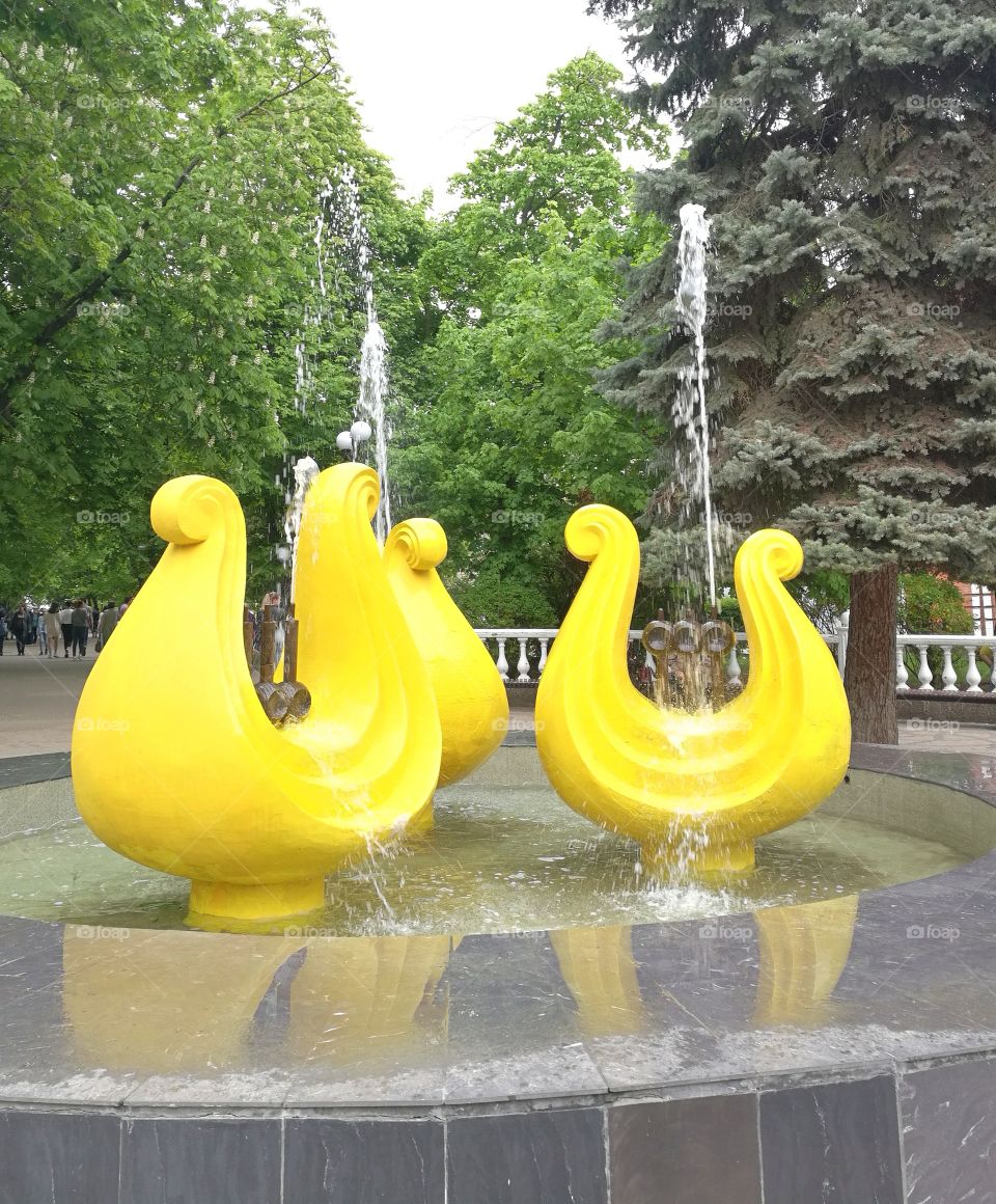 A very bright yellow fountain in the Russian city of Rostov-on-Don. Pleased with his color passers-by.