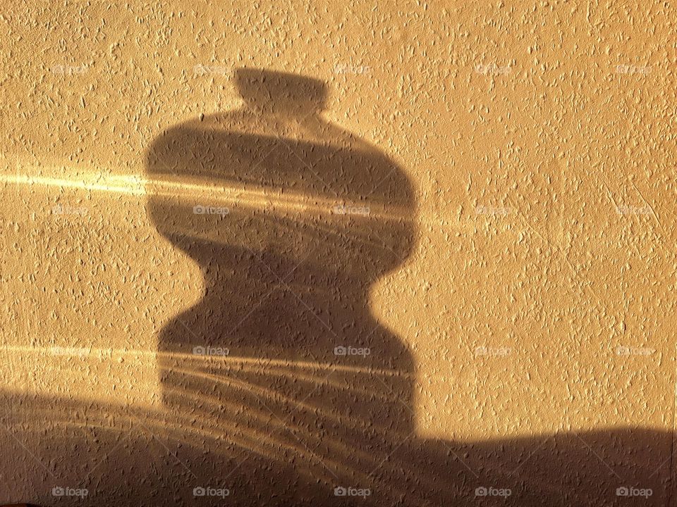 Silhouette of a bottle at sunset on wall 