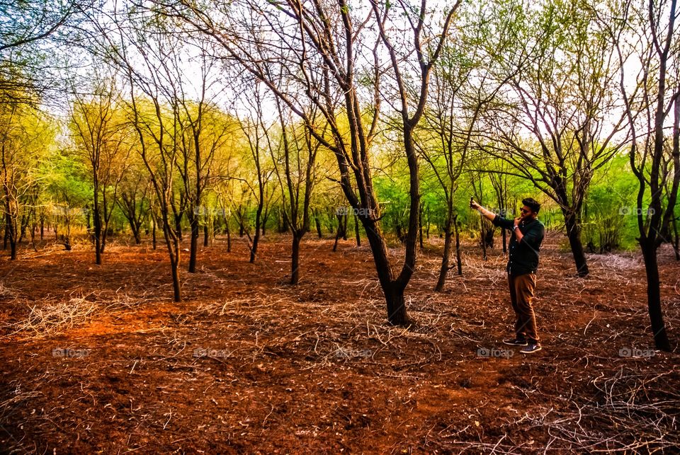 Guy taking selfi in forest 