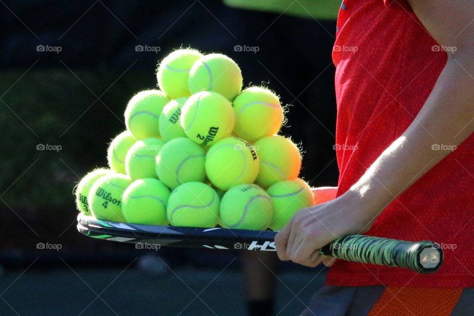 Tennis ball pyramid many balls on tennis racket