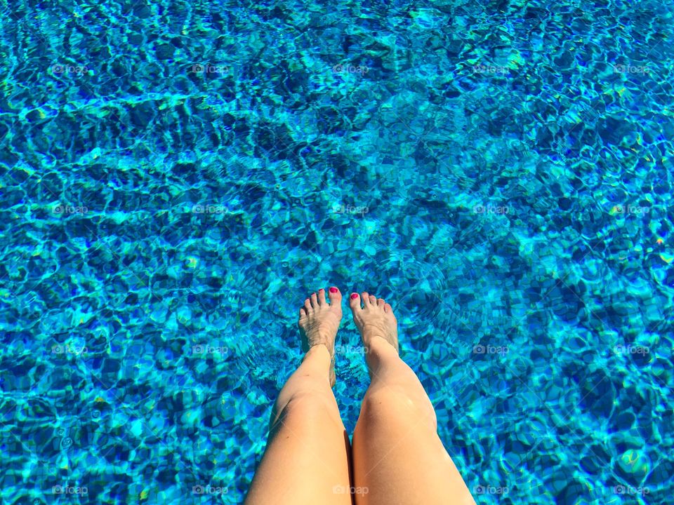 Looking down at woman’s legs in the pool