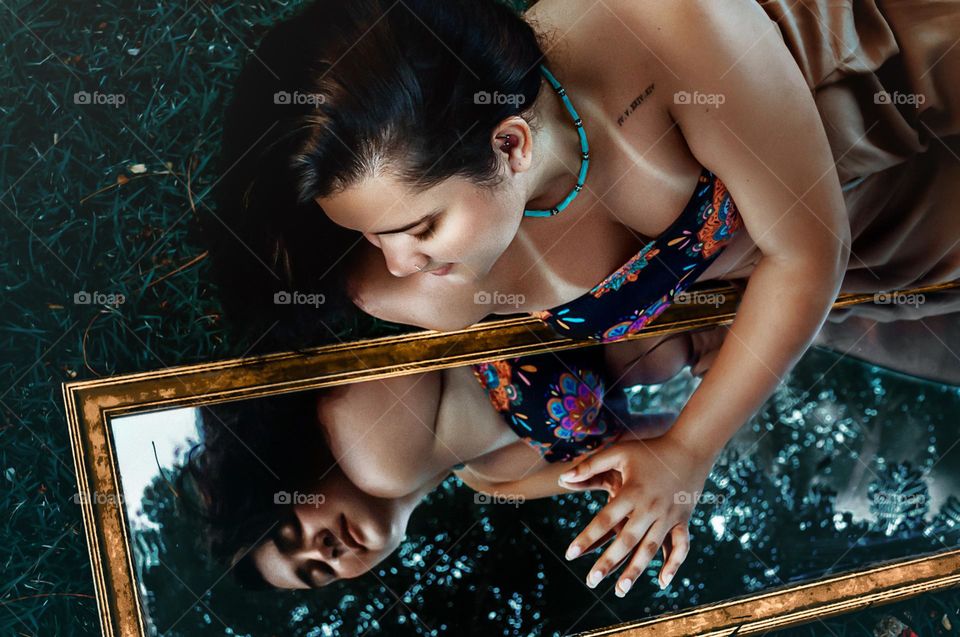 A woman’s reflection in the mirror, representing connection with herself.