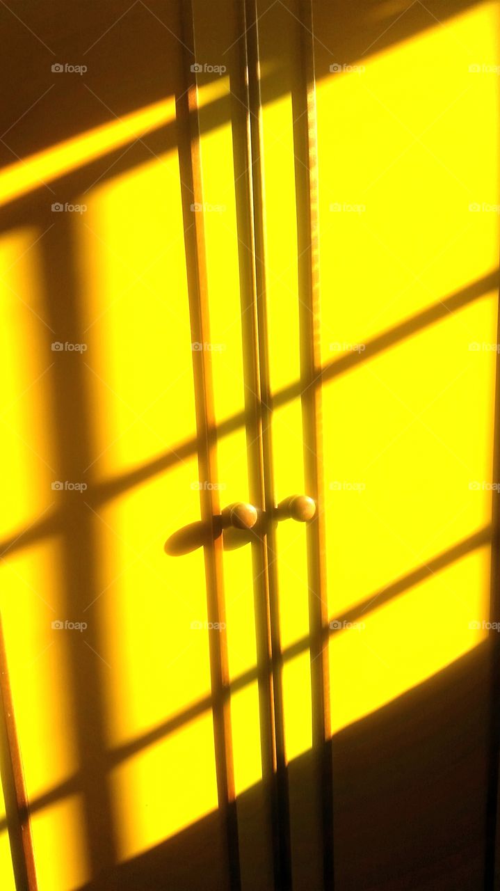 Crisscross . intense sunlight through window panes, casting grids  on my wardrobe, giving it a checkered look.