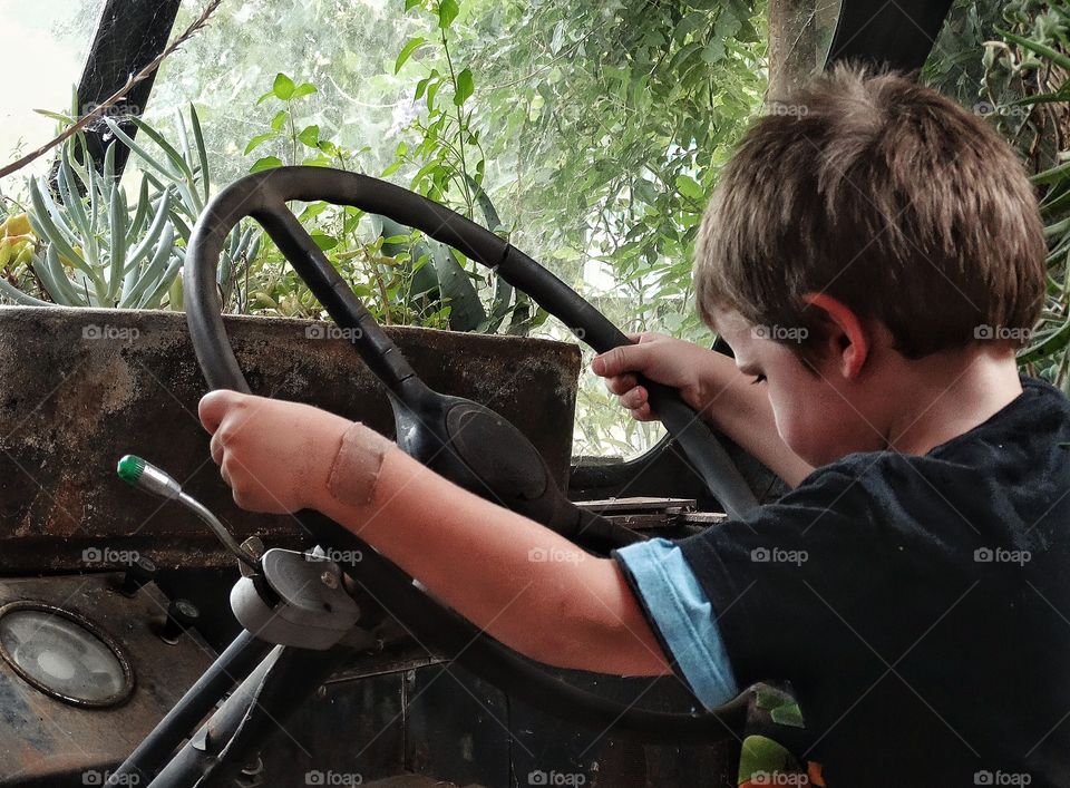 Young Boy In A Truck. Young Boy Playing In An Old Truck
