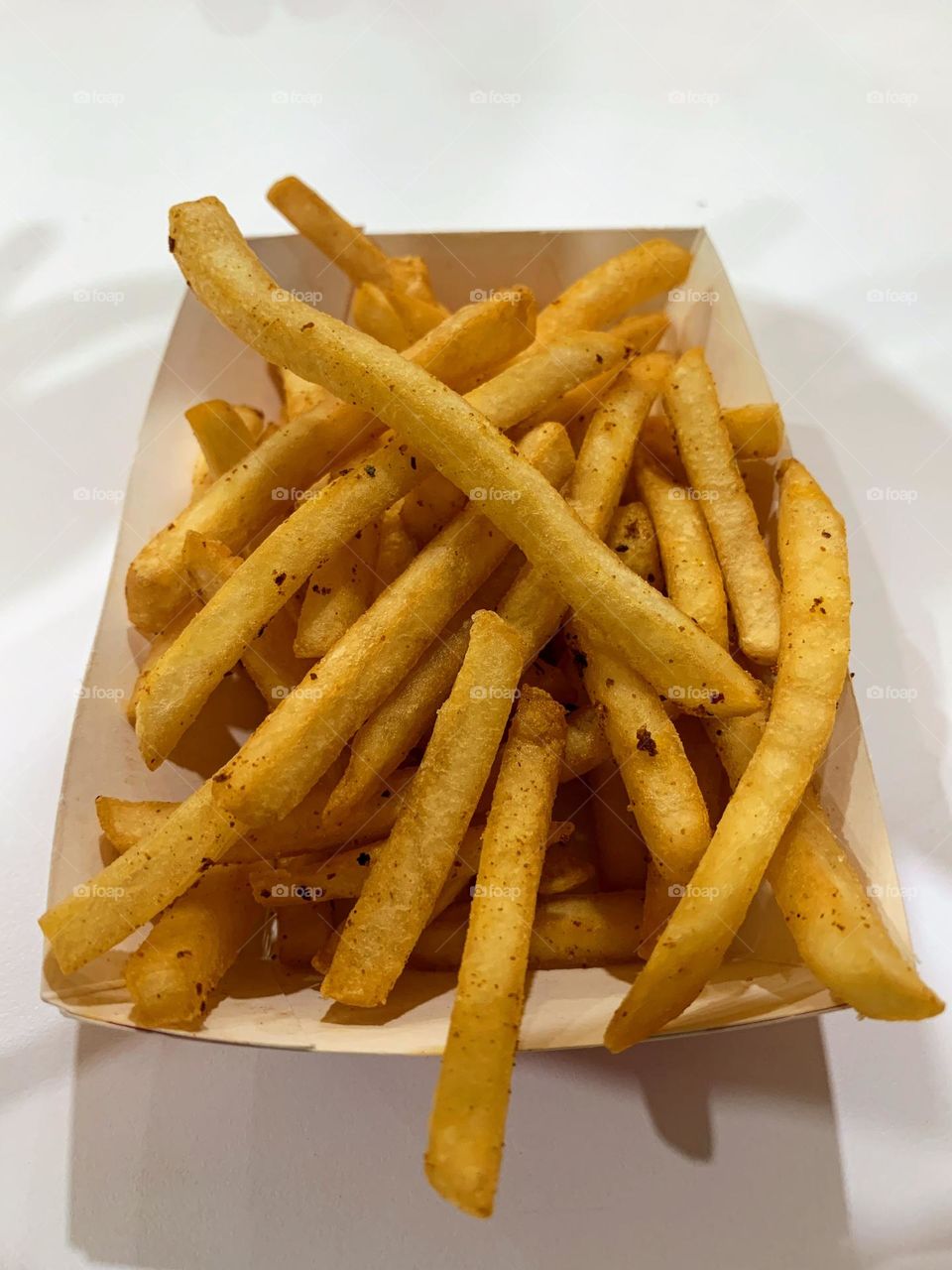 Golden and crispy French fries, perfect for snacking or as a side. Shot to showcase their delicious texture and detail. Ideal for food bloggers, restaurants, and marketing materials.