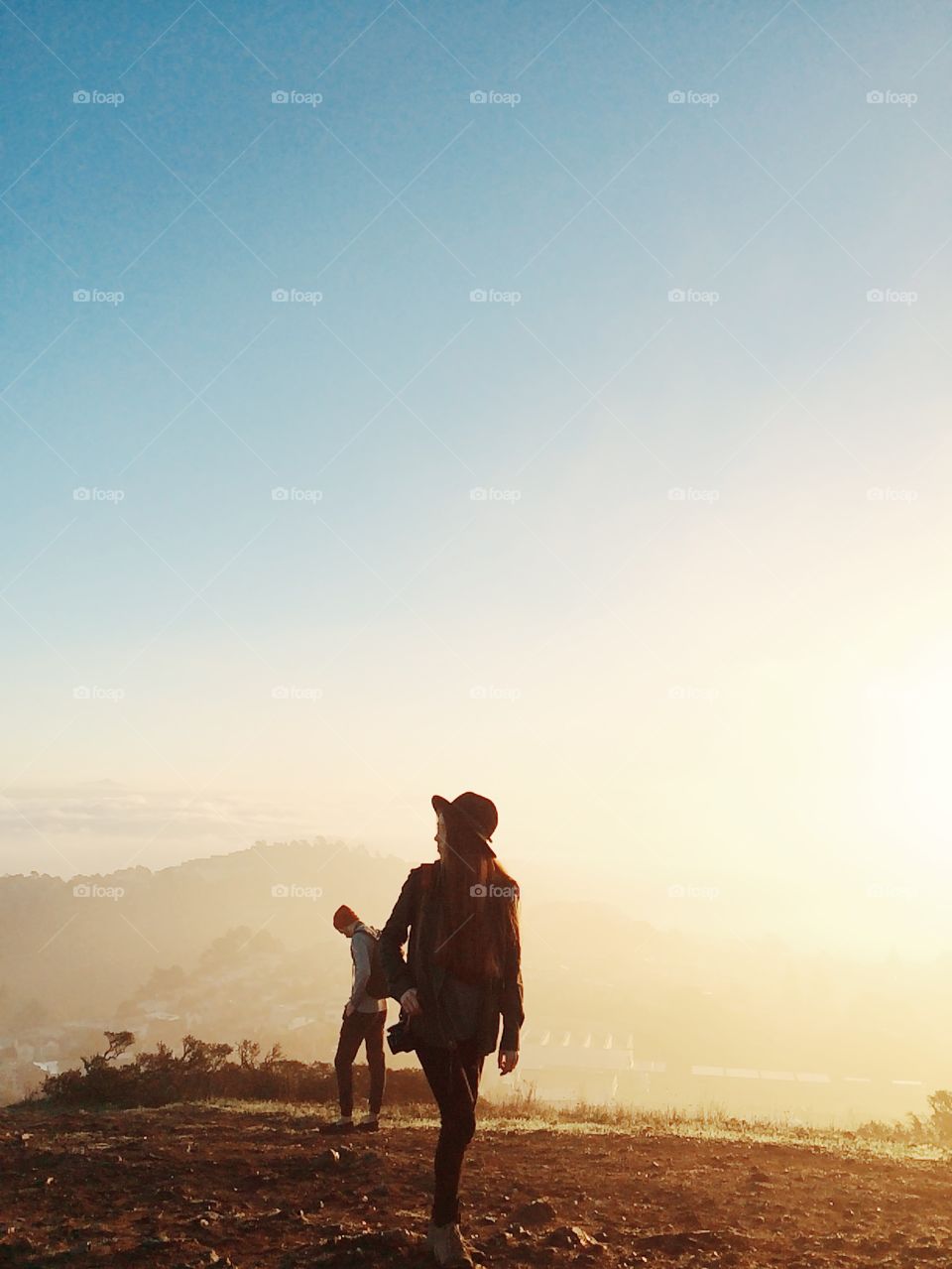 Sunrise over a foggy city... Morning hike over San Francisco. People walking around in front of the fog. 